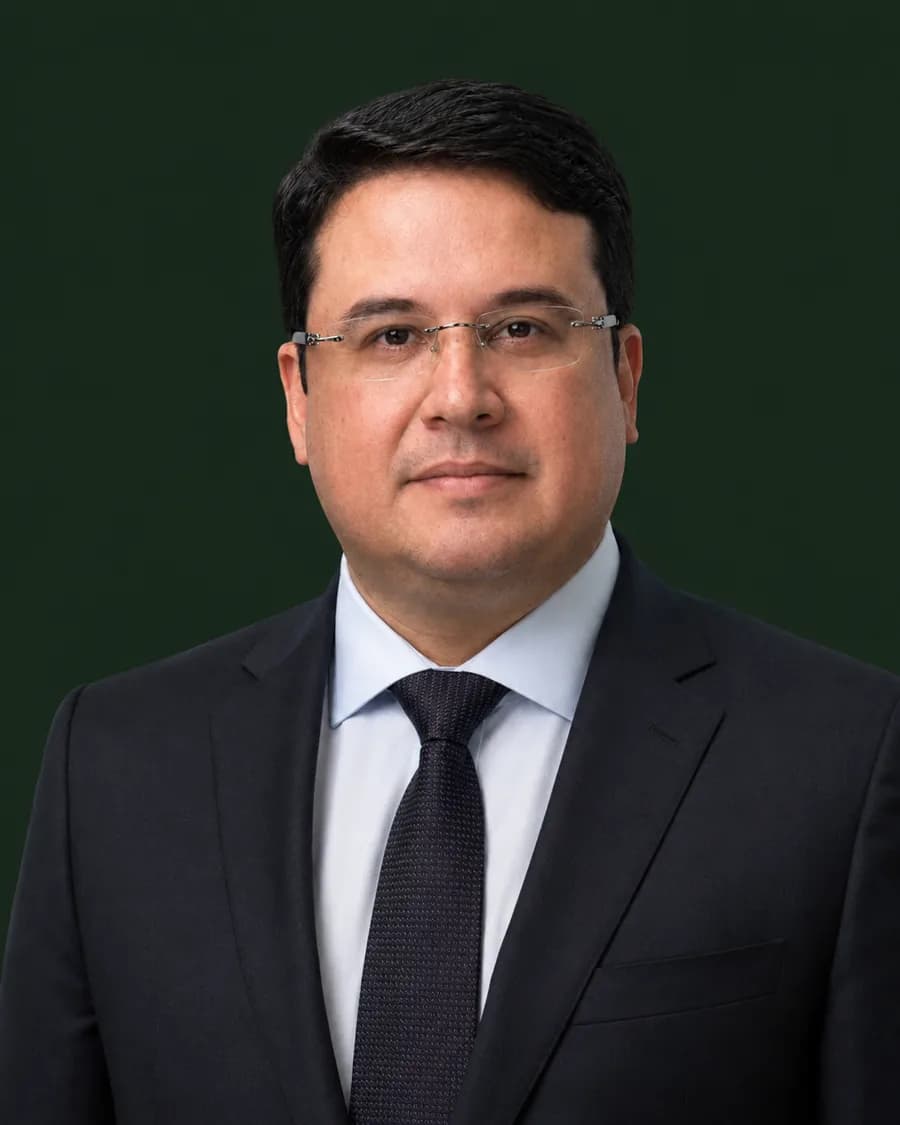 Retrato institucional do Dr. Daniel Rodrigues Cruz, fundador da DC Brazil, em traje social sobre fundo verde escuro